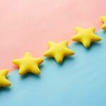 a row of yellow stars sitting on top of a blue and pink surface